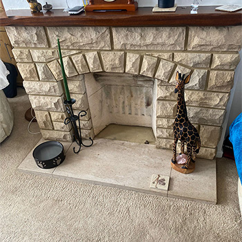 An old textured brick fireplace before renovation